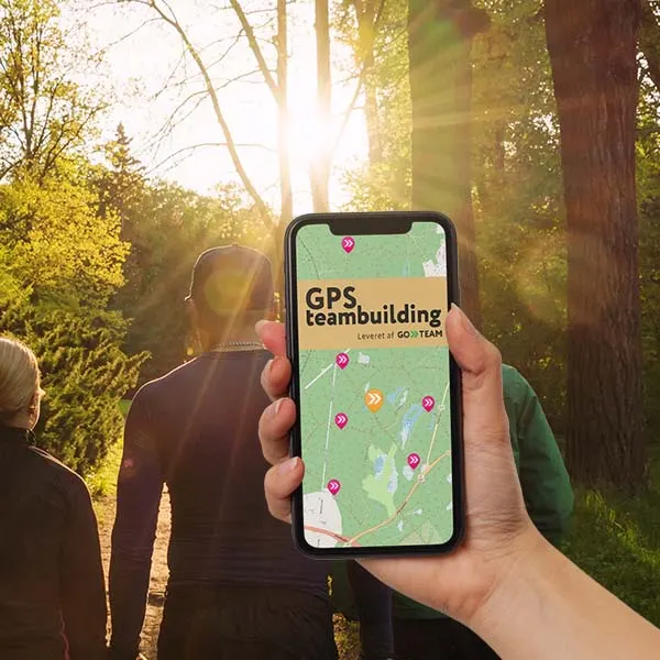 Kollegaer som er i gang med at spille GPS teambonding, på tur i skoven